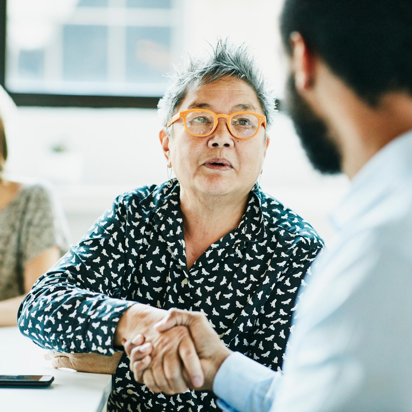 Senior businesswoman shaking hands with client after meeting in office